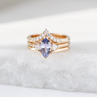 Yellow gold engagement ring with a marquise purple sapphire and two yellow gold wedding bands, all stacked on top of each other, front view