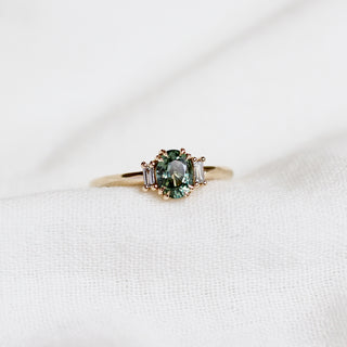 Yellow gold ring with a mint green oval cut sapphire, front view