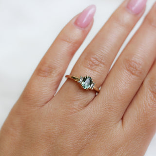 Yellow gold ring with a mint green oval cut sapphire, on hand