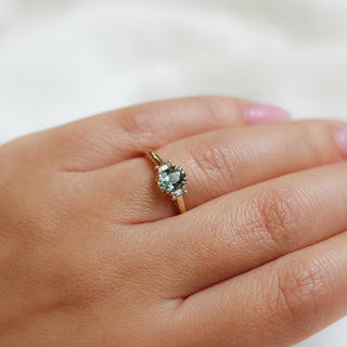 Yellow gold ring with a mint green oval cut sapphire, on hand