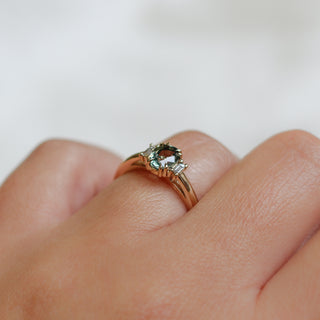 Yellow gold ring with a mint green oval cut sapphire, on hand, top view