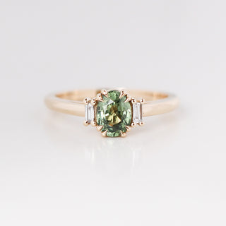 Yellow gold ring with a mint green oval cut sapphire, front view