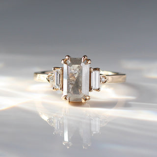 Emerald cut salt and pepper diamond ring with baguette and round diamond side stones in yellow gold, front view