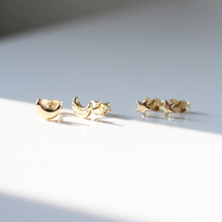Moon Stud Earrings paired with Star stud earrings in sunlight with reflections front side view