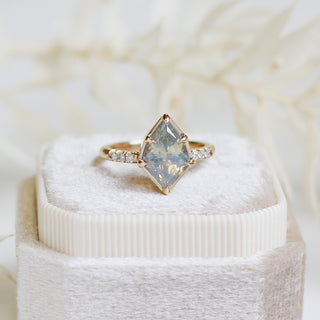 Shield shaped opalescent sapphire ring in yellow gold, on ring box