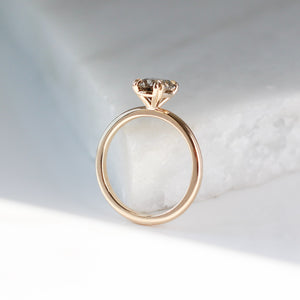 Oval cut yellow sapphire ring in yellow gold on marble profile view