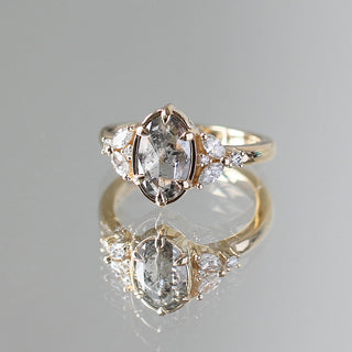 Custom engagement ring with ethically sourced oval diamond centre stone in a gold setting, with accent diamonds.