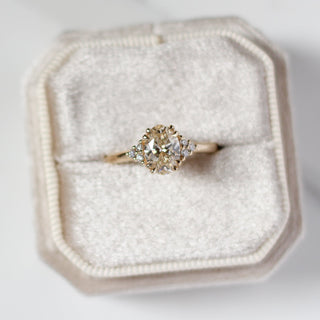 Oval diamond ring in a hexagonal box on a light background