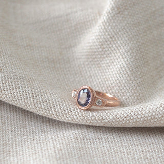 Custom engagement ring with ethically sourced oval purple sapphire centre stone in a rose gold setting, handcrafted by Yuliya Chorna at her Toronto studio.