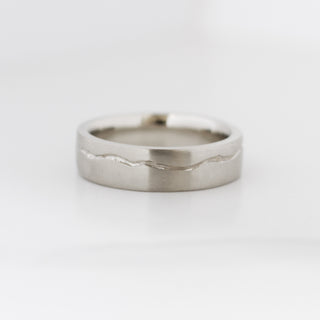 White gold wide wedding band with organic wavy line design on a white background