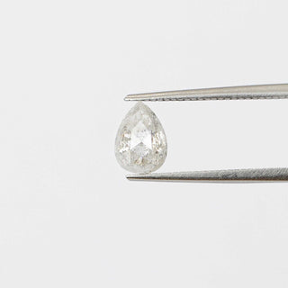 Pear shaped icy salt and pepper diamond in tongs