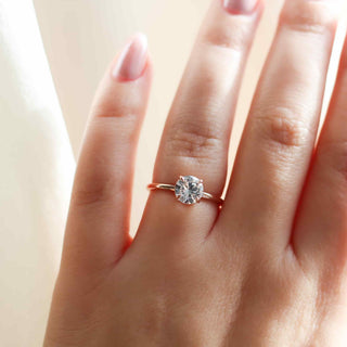 round white sapphire solitaire engagement ring worn on hand