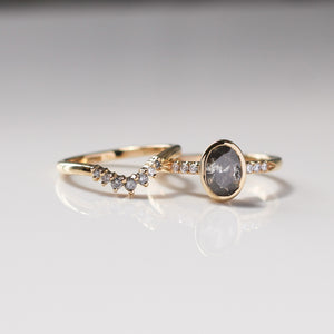 Grey Diamond stacking band in yellow gold paired with oval salt and pepper diamond gold ring with reflection front view