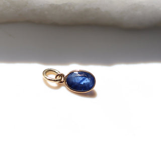 Blue Sapphire Bezel Charm in sunlight side view 