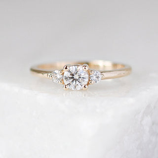 Custom three stone round moissanite engagement ring in a gold setting, handcrafted by Yuliya Chorna at her Toronto studio.