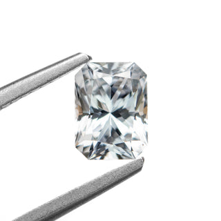 White radiant cut sapphire on white background, held by tweezers