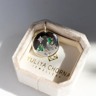 White gold round medallion pendant with diamonds and emeralds in a pendant box
