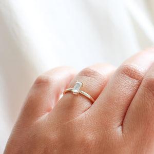 White sapphire ring on finger side view