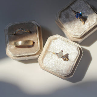 Gold wedding bands and two handcrafted engagement rings with ethically sourced gemstones.