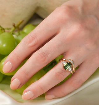 Emerald engagement ring in signature gold ring setting with ethically sourced diamonds and curved wedding band.