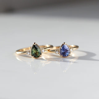 Two three stone engagement rings with pear cut sapphires in yellow gold, front view