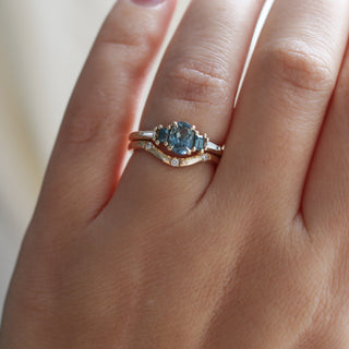 Yellow gold ring with blue sapphires and a three diamond contour band, on hand
