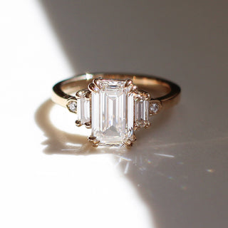 Yellow gold engagement ring with an elongated emerald cut lab diamond and lab diamond accents