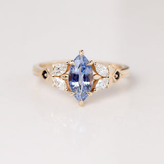 Yellow gold engagement ring in a floral style, with a marquise blue sapphire centre stone and marquise white diamond and round blue sapphire accents