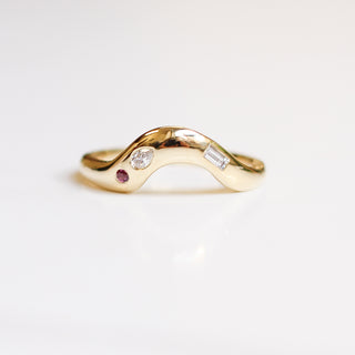 Organic style curved wedding band in yellow gold, with two different shaped diamonds and one pink sapphire set into the band. 