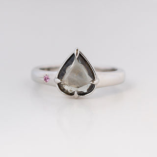 Platinum engagement ring with a purple colour change pear sapphire and a pink sapphire accent on the band 