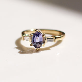 Yellow gold engagement ring with a purple hexagon sapphire and baguette white diamond accents