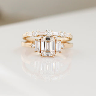 Yellow gold wedding band with baguette cut and round brilliant cut lab diamonds stacked with an emerald cut white diamond engagement ring, front view