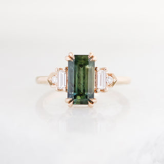 Elongated emerald cut green sapphire ring with baguette and round diamond side stones in yellow gold, front view
