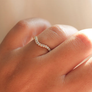 Diamond pave curved wedding band in yellow gold, on hand