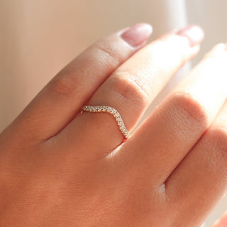 Diamond pave curved wedding band in yellow gold, on hand
