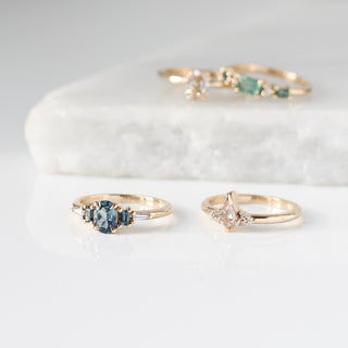 Various gold rings with gemstones on a white marble surface