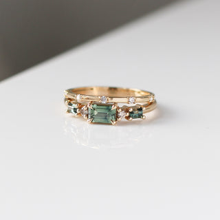 Yellow gold ring with green sapphires and a diamond straight band, front view
