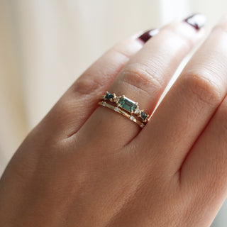 Yellow gold ring with green sapphires and a diamond straight band, on hand
