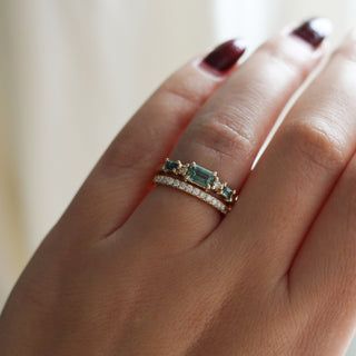 Yellow gold ring with green sapphires and a diamond straight band, on hand
