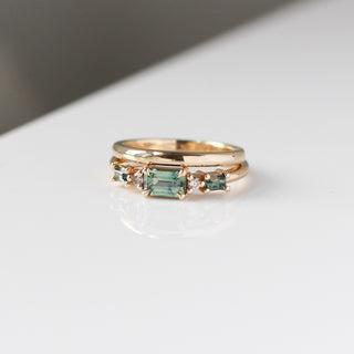 Yellow gold ring with green sapphires and a yellow gold straight band, front view