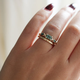 Yellow gold ring with green sapphires and a yellow gold straight band, on hand