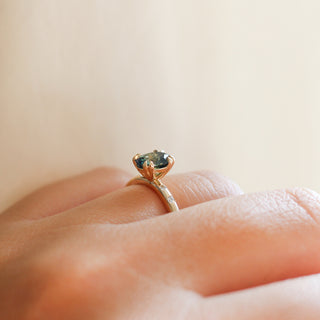 Yellow gold ring with green sapphire, on hand, side view