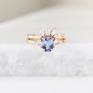 Yellow gold crown contour band with clear diamonds and a yellow gold ring with a blue sapphire, front view