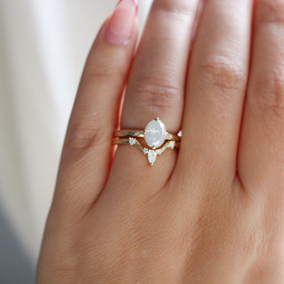 Yellow gold pointed contour band with white diamonds and a yellow gold ring with a white diamond, on hand