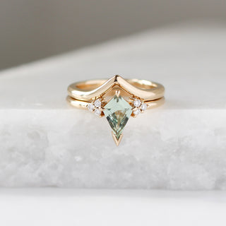 Yellow gold ring with a light green kite cut sapphire and a yellow gold pointed wedding band, front view