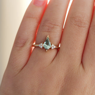 Yellow gold ring with a light green kite cut sapphire, on hand
