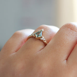 Yellow gold ring with a light green kite cut sapphire, on hand, side view
