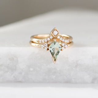 Yellow gold ring with a light green kite cut sapphire and a yellow gold pointed wedding band with round white diamonds, front view