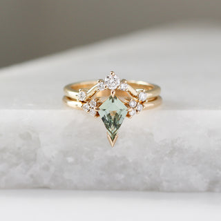 Yellow gold ring with a light green kite cut sapphire and a yellow gold curved wedding band with round white diamonds, front view