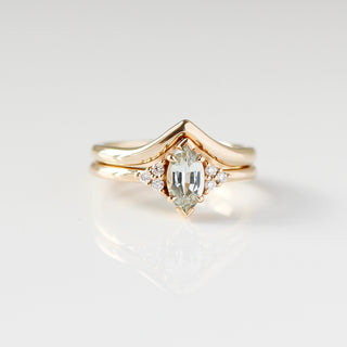 Yellow gold ring with a light green marquise cut sapphire with a yellow gold pointed wedding band, front view